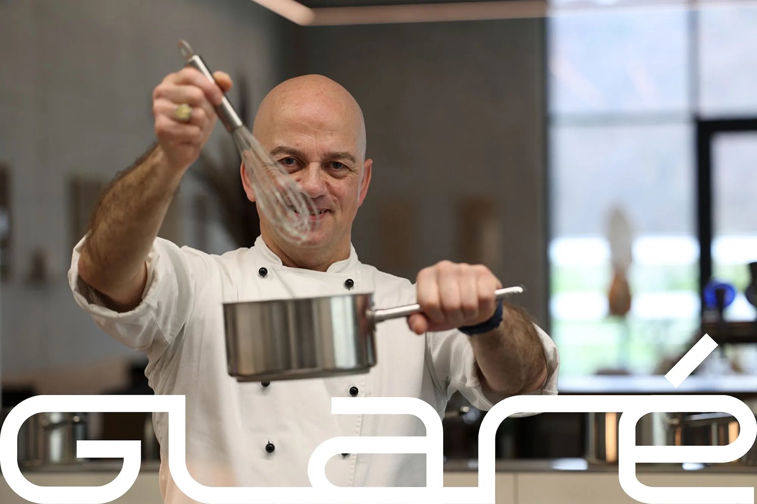 The chef holding a whisk and a pan above the wordmark set large in white